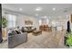 Open living room with tile floors, gray sectional sofa, and kitchen view at 5437 Misty Oak Cir, Davenport, FL 33837