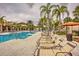 Pool area with lounge chairs and palm trees at 5437 Misty Oak Cir, Davenport, FL 33837