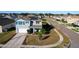 Aerial view of a charming two-story home with solar panels, a well-maintained lawn, and a quiet neighborhood at 6163 Forest Ridge Way, Winter Haven, FL 33881