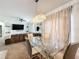 Open concept dining room with glass table and view of living room at 6163 Forest Ridge Way, Winter Haven, FL 33881