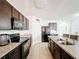 Functional kitchen with dark wood cabinets, granite countertops, and modern black appliances at 6163 Forest Ridge Way, Winter Haven, FL 33881