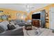 Living room features gray sofas and a large TV at 7403 Glen Oaks Way # 82, Winter Park, FL 32792