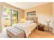 Bright bedroom with a large bed, tufted bench, and sliding glass doors to the outside at 7535 Brooklyn Dr, Kissimmee, FL 34747