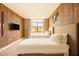 Shared bedroom with two comfortable beds, decorative wood wall, and large windows at 7535 Brooklyn Dr, Kissimmee, FL 34747