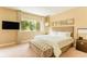 Bright bedroom with a large bed, tufted bench, and a window view at 7535 Brooklyn Dr, Kissimmee, FL 34747