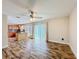 Open living room with kitchen view, wood-look floors, and ceiling fan at 1001 Dampierre Ct, Kissimmee, FL 34759