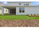 Backyard featuring lush green grass, mulched garden beds, and a covered patio at 13200 Faro Ct # 44, Winter Garden, FL 34787