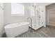 Bright bathroom features a soaking tub and a glass enclosed shower with stylish fixtures and gray tile floors at 13200 Faro Ct # 44, Winter Garden, FL 34787