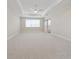 Bright bedroom features tray ceiling, neutral walls, carpeted floors, and ensuite bathroom access at 13200 Faro Ct # 44, Winter Garden, FL 34787