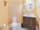 Powder room with a dark brown vanity, marble countertop, and decorative mirror at 13940 Arclid St, Orlando, FL 32832