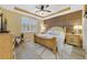 Spacious main bedroom showcases a tray ceiling, wood accent wall, and a large window with plantation shutters at 13940 Arclid St, Orlando, FL 32832