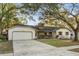 Single story home with attached garage, landscaping, and a large driveway at 1404 N Cove Blvd, Longwood, FL 32750