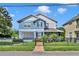 Two-story light blue house with gray accents, a fenced yard, and a brick walkway at 1521 Harmon Ave, Winter Park, FL 32789