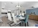 Dining room with white table, chandelier, and teal chairs at 1564 Flange Dr, Davenport, FL 33896