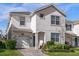 Two-story house with gray exterior, two-car garage, and landscaped yard at 1564 Flange Dr, Davenport, FL 33896