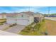 Aerial view of two-car garage home with paver driveway, and landscaped yard at 1987 Key Bay Trl, Kissimmee, FL 34747