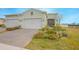 Single-story home with two-car garage, landscaped yard, and paver driveway at 1987 Key Bay Trl, Kissimmee, FL 34747