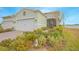 Landscaped yard, two-car garage, and light-green exterior at 1987 Key Bay Trl, Kissimmee, FL 34747