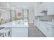 Open kitchen with white island, quartz countertops, and stainless steel appliances at 1987 Key Bay Trl, Kissimmee, FL 34747