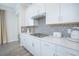 White kitchen cabinets, gas cooktop, and gray hexagon backsplash at 1987 Key Bay Trl, Kissimmee, FL 34747
