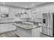 Modern kitchen with white cabinets, gray island and stainless steel appliances at 2789 Ruby Rose Ln, St Cloud, FL 34771