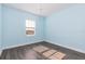 Empty light blue bedroom has wood floors and modern chandelier at 2918 Sand Oak Loop, Apopka, FL 32712