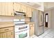 Kitchen with wood cabinets, white appliances and stainless steel fridge at 429 Copperstone Cir, Casselberry, FL 32707