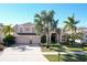 Two-story house with three-car garage, landscaping, and palm trees at 437 Prestwick Dr, Davenport, FL 33897