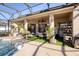 Inviting pool area with covered patio, seating, and lush landscaping at 437 Prestwick Dr, Davenport, FL 33897