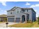 Two-story house with gray siding, two-car garage, and landscaped yard at 4538 Cortland Dr, Davenport, FL 33837