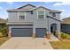 Two-story house with gray siding, two-car garage, and landscaped yard at 4538 Cortland Dr, Davenport, FL 33837