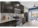 Modern kitchen with dark wood cabinets, granite countertops, and stainless steel appliances at 4538 Cortland Dr, Davenport, FL 33837