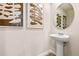 Elegant powder room with pedestal sink and framed art at 5649 Brosnan Rd, Saint Cloud, FL 34771