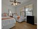 Bedroom with two twin beds, ceiling fan, and window at 914 Charo Pkwy # 113, Davenport, FL 33897