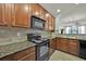 Modern kitchen with granite countertops and wood cabinets at 914 Charo Pkwy # 113, Davenport, FL 33897