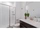 Bathroom with single vanity, glass shower, and dark cabinets at 1060 Leader St, Davenport, FL 33896