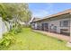 Grass yard with screened porch and white fence at 110 Dianne Dr, Ormond Beach, FL 32176