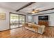 Bright living room featuring hardwood floors, exposed beams, and sliding glass doors to patio at 110 Dianne Dr, Ormond Beach, FL 32176