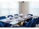 Elegant dining room with glass table and blue velvet chairs at 1176 Challenge Dr, Davenport, FL 33896