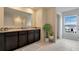 Bathroom with dark vanity, double sinks, and a large mirror at 1177 Alstonia Ln, Mount Dora, FL 32757