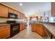 Kitchen with wooden cabinets, black appliances, and granite countertops at 12002 Great Commission Way, Orlando, FL 32832