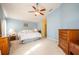 Main bedroom with light blue walls, a king-size bed, and wooden dresser at 12002 Great Commission Way, Orlando, FL 32832