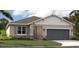 One-story home with gray siding, dark gray garage door, and landscaping at 1232 White Ash Loop, Deland, FL 32720