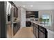 Modern kitchen with dark cabinetry, granite countertops, and stainless steel appliances at 1232 White Ash Loop, Deland, FL 32720