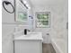 Clean bathroom with white vanity, marble shower, and window at 124 Mercado Ave, Orlando, FL 32807