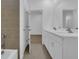 Double vanity bathroom with white cabinets and brown tile floors at 1244 White Ash Loop, Deland, FL 32720