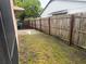 A view of the backyard showing the fence line and the grassy area extending to the side of the house at 1332 Azalea Way, Winter Garden, FL 34787