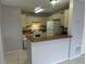 Kitchen with white appliances and cabinets, and a wooden countertop, with a view of the entryway at 1332 Azalea Way, Winter Garden, FL 34787