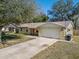 Front view of a single-story house with a driveway and mature trees at 137 N Nowell St, Orlando, FL 32835