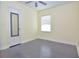 Bright bedroom with grey flooring, a window with blinds, and a door with a mirror at 1516 17Th Nw St, Winter Haven, FL 33881